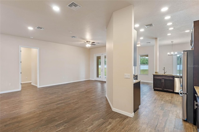 interior space with wood-type flooring, sink, ceiling fan with notable chandelier, and a textured ceiling