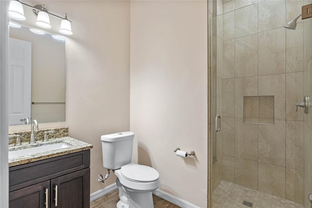 bathroom with vanity, toilet, and a shower with shower door