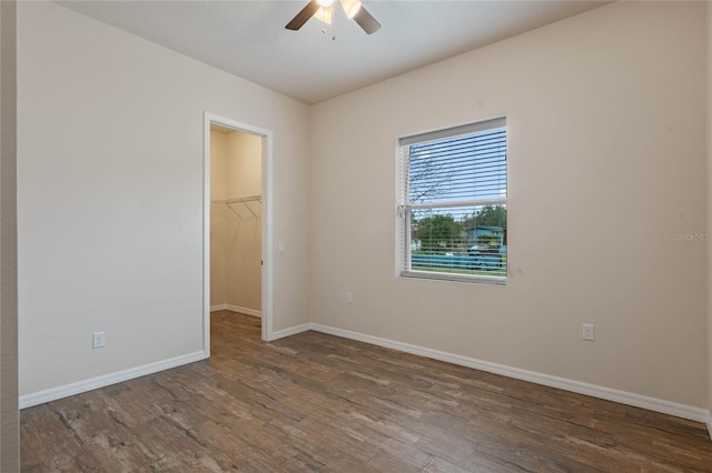 unfurnished room featuring dark wood-type flooring and ceiling fan