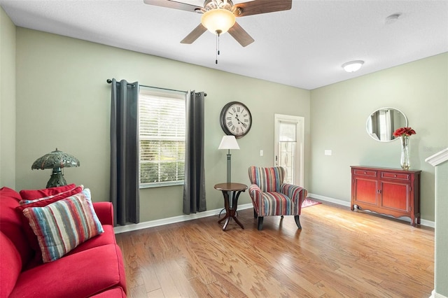 living area with ceiling fan and light hardwood / wood-style flooring