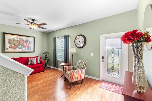 sitting room with ceiling fan and wood-type flooring