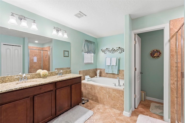 bathroom with vanity, shower with separate bathtub, a textured ceiling, and tile patterned flooring