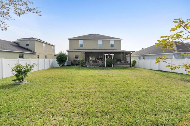 back of property with a sunroom and a yard