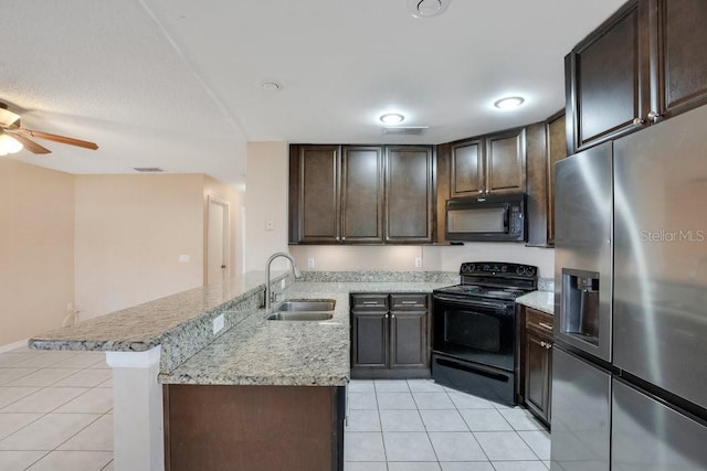 kitchen with black appliances, sink, kitchen peninsula, light stone counters, and light tile patterned floors