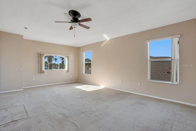 unfurnished room with light carpet, ceiling fan, and a textured ceiling