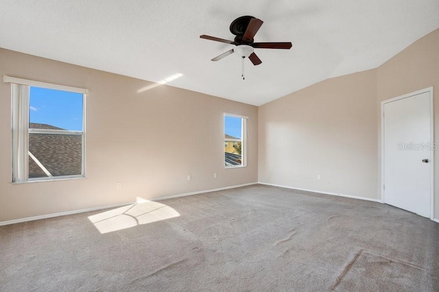 carpeted empty room featuring vaulted ceiling and ceiling fan