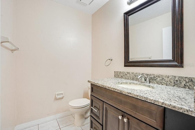 bathroom featuring a textured ceiling, toilet, vanity, and tile patterned flooring