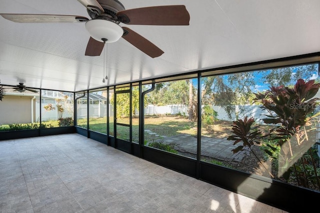 unfurnished sunroom with ceiling fan