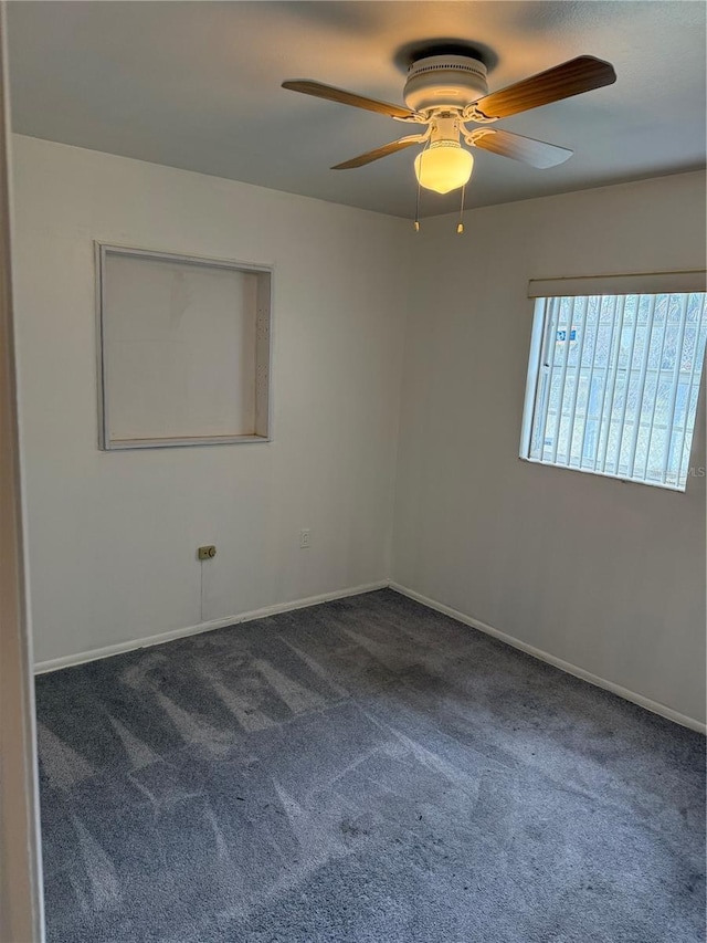 empty room with dark carpet, baseboards, and ceiling fan