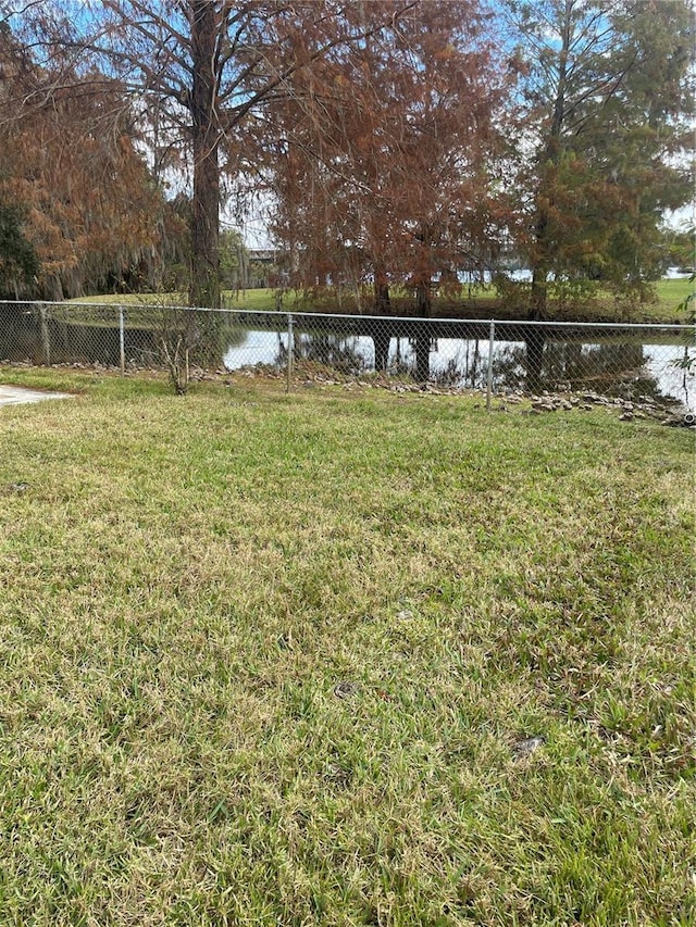 view of yard featuring a water view and fence