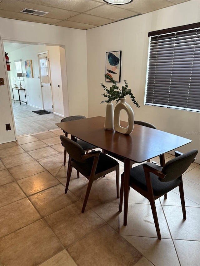 dining room featuring light tile patterned floors, a paneled ceiling, and visible vents