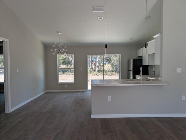 kitchen featuring dark hardwood / wood-style floors, kitchen peninsula, hanging light fixtures, white cabinets, and a chandelier