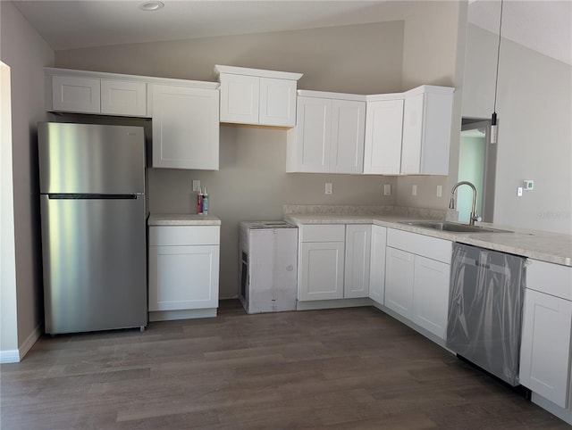 kitchen featuring appliances with stainless steel finishes, pendant lighting, white cabinetry, and sink