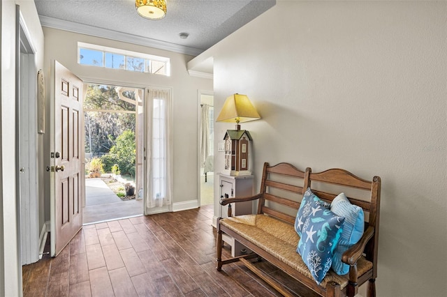 entrance foyer with ornamental molding, dark hardwood / wood-style floors, and a textured ceiling