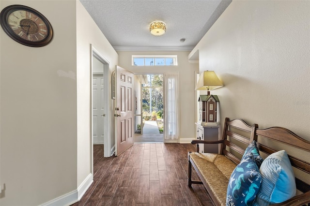 doorway with crown molding, dark hardwood / wood-style floors, and a textured ceiling