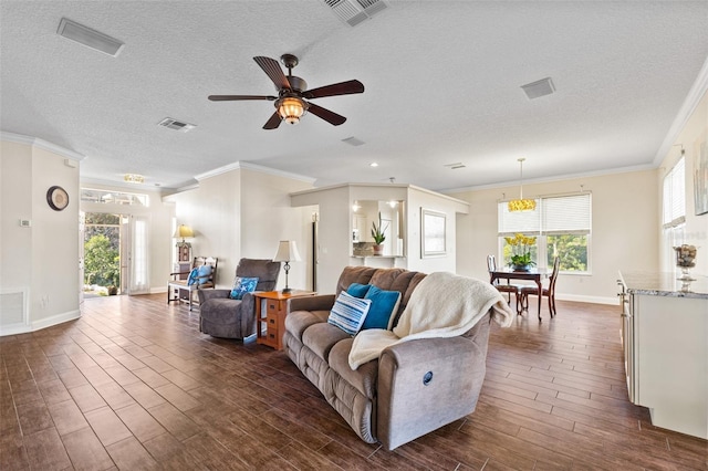 living room featuring crown molding, ceiling fan, and a textured ceiling