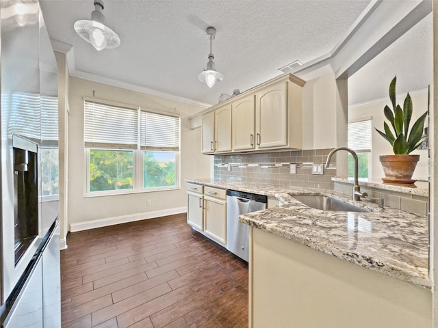 kitchen with decorative light fixtures, sink, stainless steel dishwasher, cream cabinets, and dark wood-type flooring