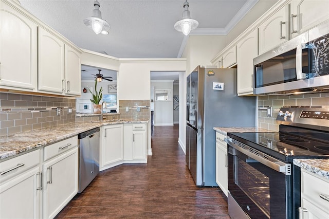 kitchen featuring sink, hanging light fixtures, ornamental molding, stainless steel appliances, and dark wood-type flooring