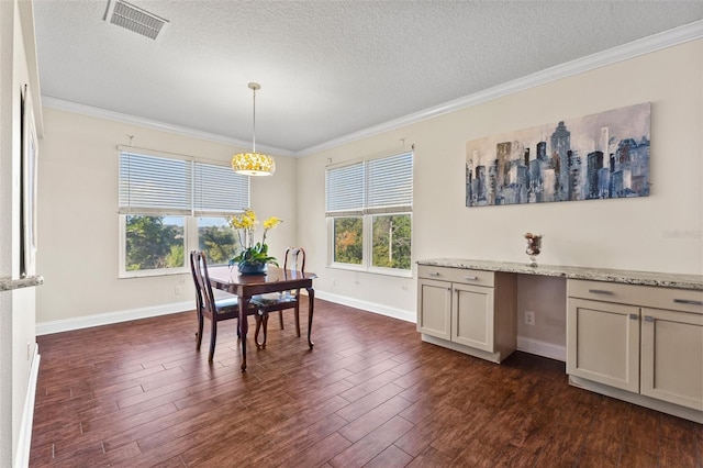 dining space featuring dark wood-type flooring, crown molding, and a textured ceiling