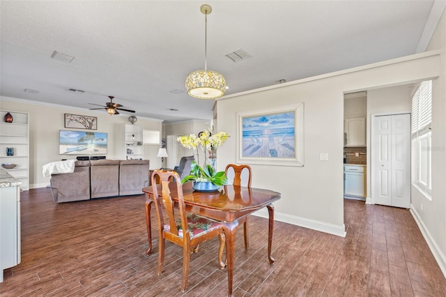 dining space with crown molding, dark wood-type flooring, and ceiling fan