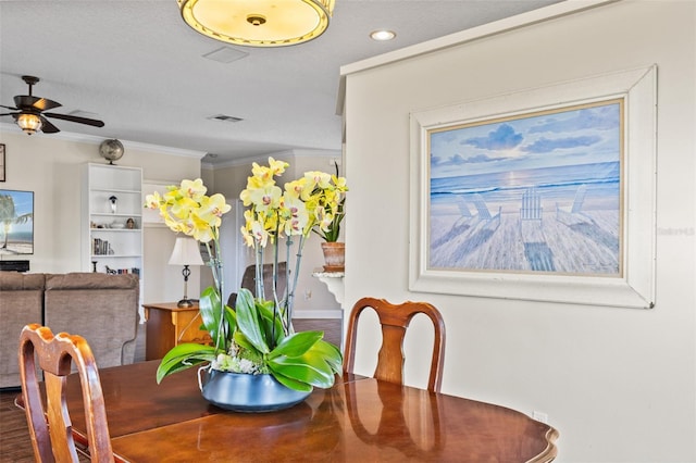 dining room featuring hardwood / wood-style floors, a textured ceiling, ornamental molding, and ceiling fan