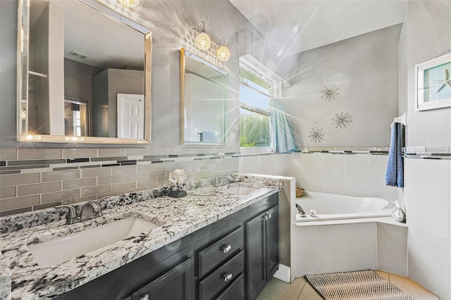 bathroom with tiled bath, tile walls, decorative backsplash, tile patterned flooring, and vanity