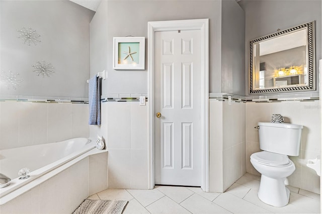 bathroom with tile patterned floors, toilet, tile walls, and tiled tub