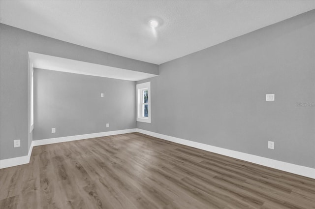 empty room featuring a textured ceiling and hardwood / wood-style floors