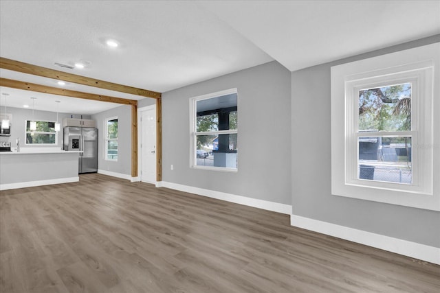 unfurnished living room with dark hardwood / wood-style floors and beamed ceiling