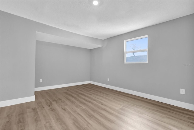 additional living space with a textured ceiling and light hardwood / wood-style floors