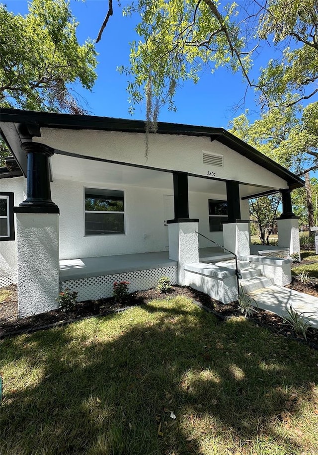 3206 N 29th St, Tampa, FL 33605 - rear view of property with stucco siding, a lawn, and covered porch