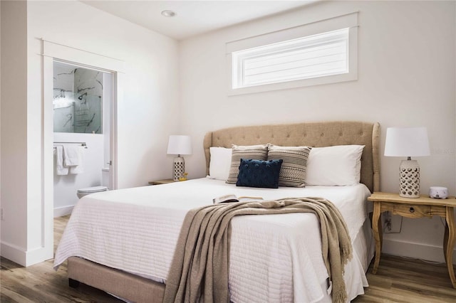 bedroom featuring ensuite bath and wood-type flooring