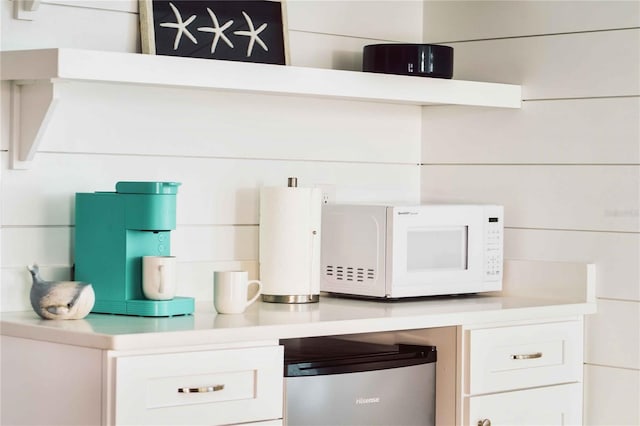 interior space with refrigerator and white cabinets