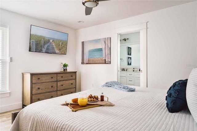 bedroom featuring ensuite bath, ceiling fan, and light wood-type flooring