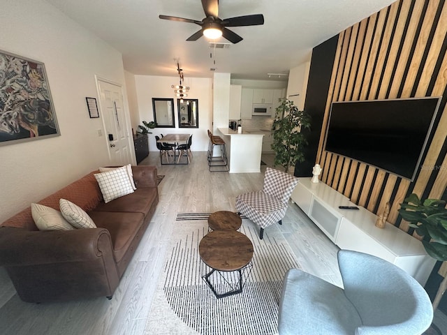 living room featuring ceiling fan and light hardwood / wood-style flooring