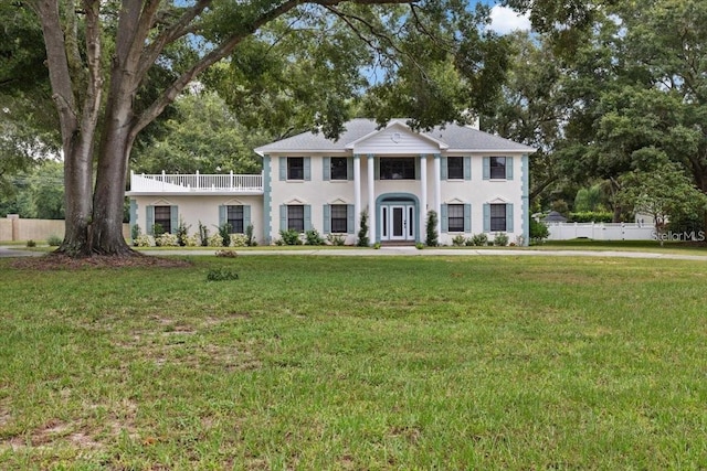 neoclassical home featuring a front yard