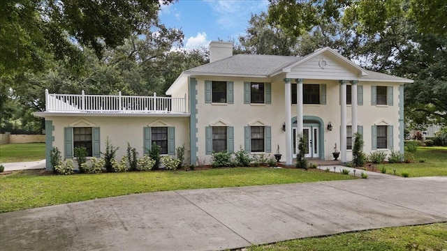 view of front of property with a front lawn and a balcony