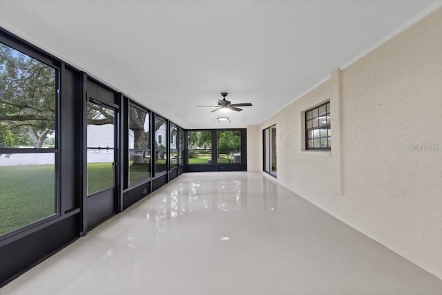 unfurnished sunroom featuring ceiling fan