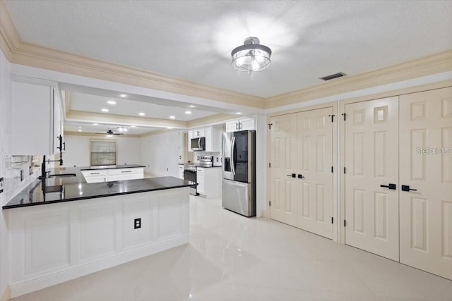 kitchen featuring white cabinetry, stainless steel appliances, kitchen peninsula, ornamental molding, and ceiling fan