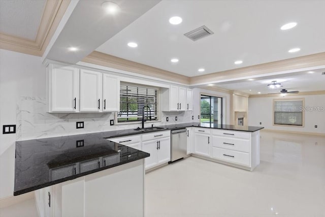 kitchen featuring kitchen peninsula, ceiling fan, dark stone countertops, stainless steel dishwasher, and sink