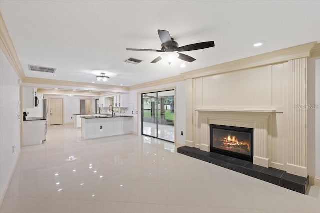 unfurnished living room featuring tile patterned floors, a tile fireplace, and crown molding