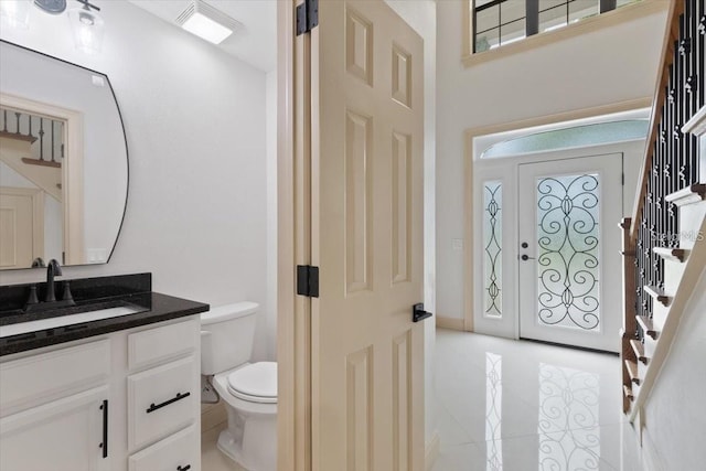 bathroom with toilet, tile patterned floors, and vanity