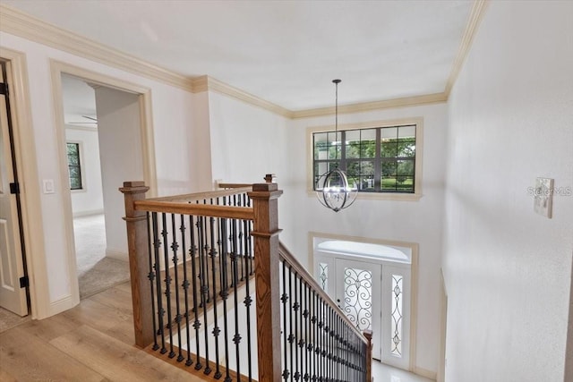 interior space with a wealth of natural light, ornamental molding, a chandelier, and hardwood / wood-style floors