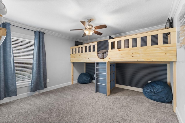 unfurnished bedroom with ceiling fan, a textured ceiling, ornamental molding, and carpet flooring