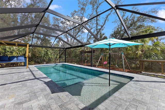 view of pool with a patio area, glass enclosure, and a playground