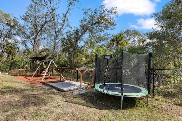 view of playground with a trampoline and a yard