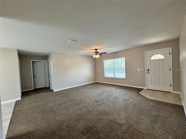 entrance foyer with carpet, ceiling fan, and a textured ceiling