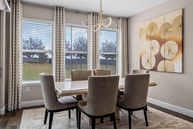 dining room with dark wood-type flooring and a chandelier