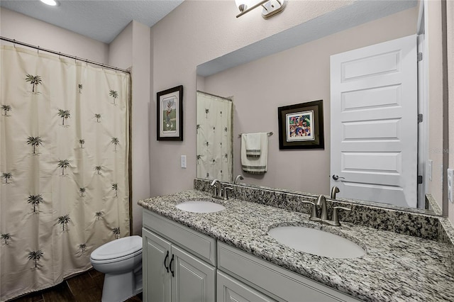 bathroom with toilet, vanity, wood-type flooring, a textured ceiling, and a shower with shower curtain