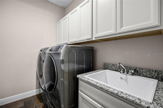 laundry room featuring cabinets, washer and clothes dryer, dark hardwood / wood-style floors, and sink